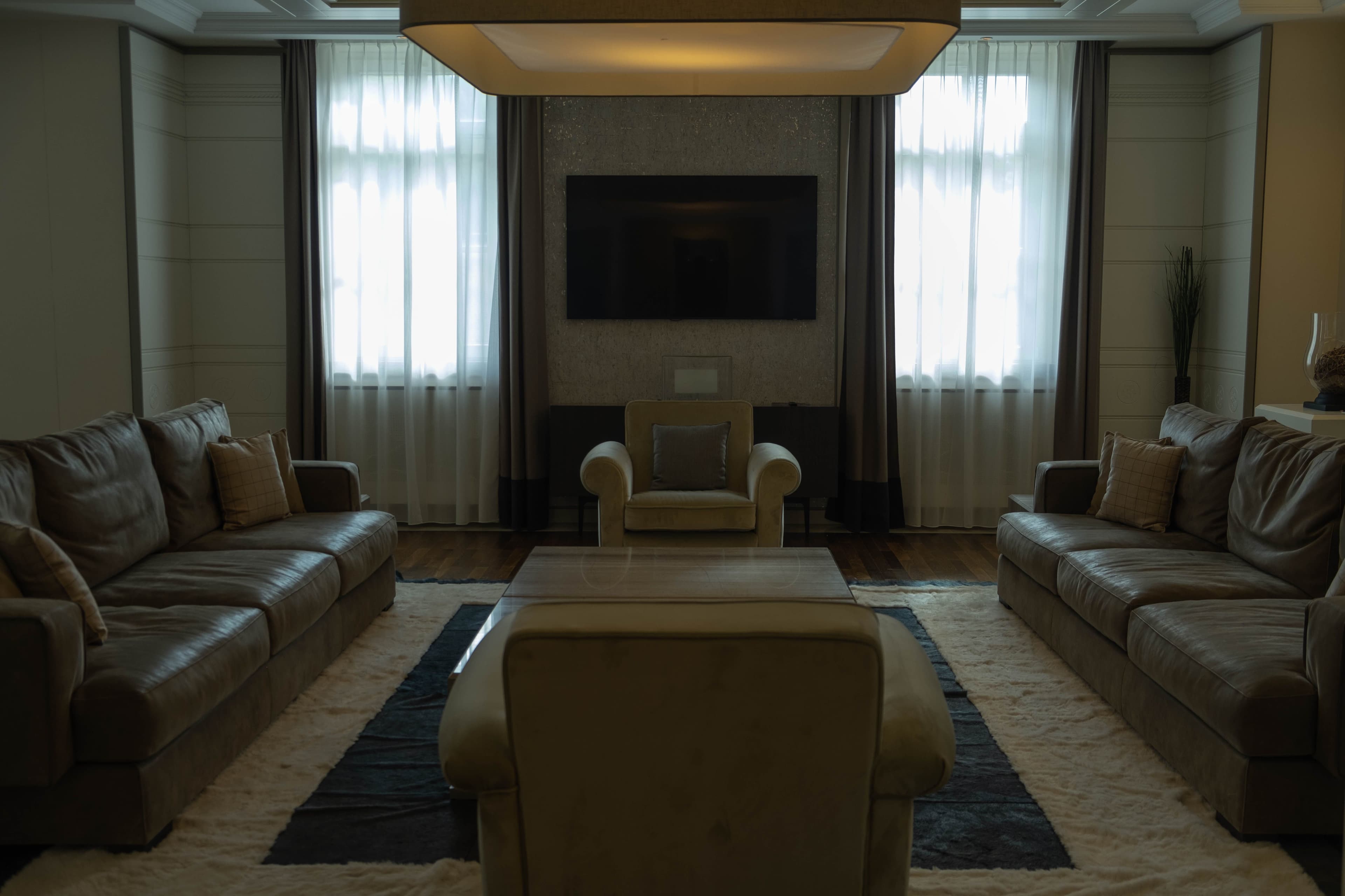 A dark modern living room with warm layered lighting