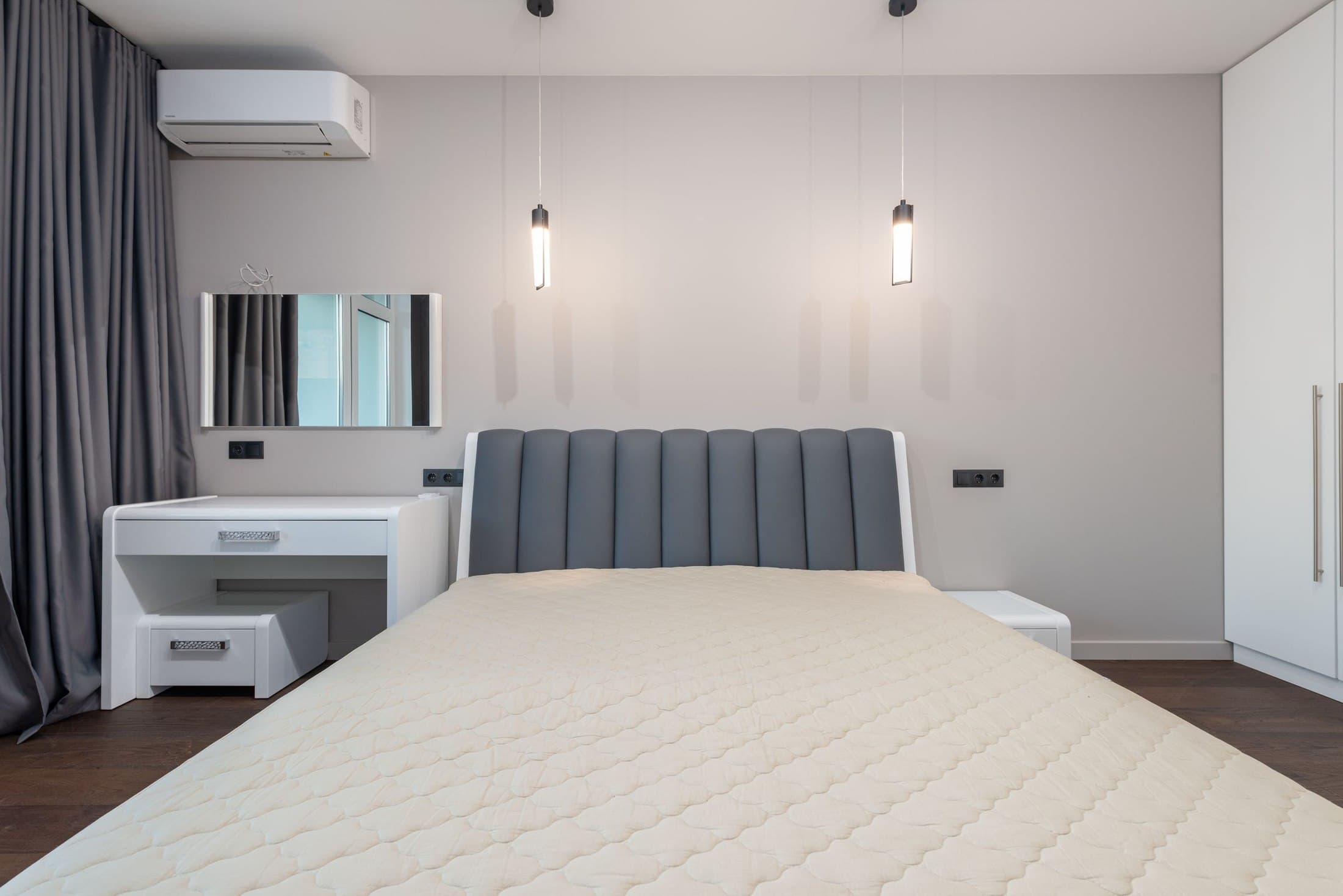 Hotel bedroom with a wardrobe, desk, mirror and pendant lights