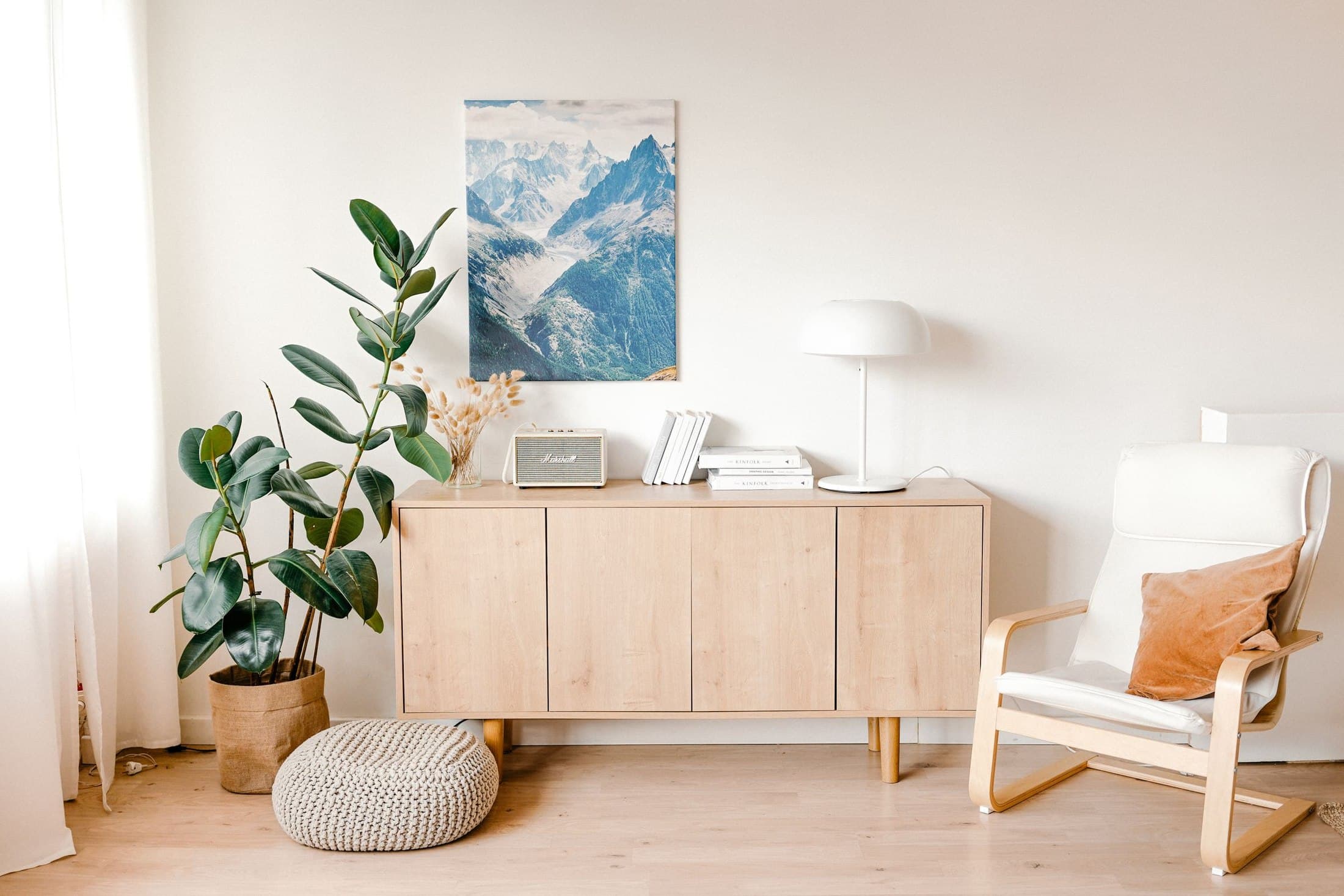 Pale timber cabinet and armchair in a bright room