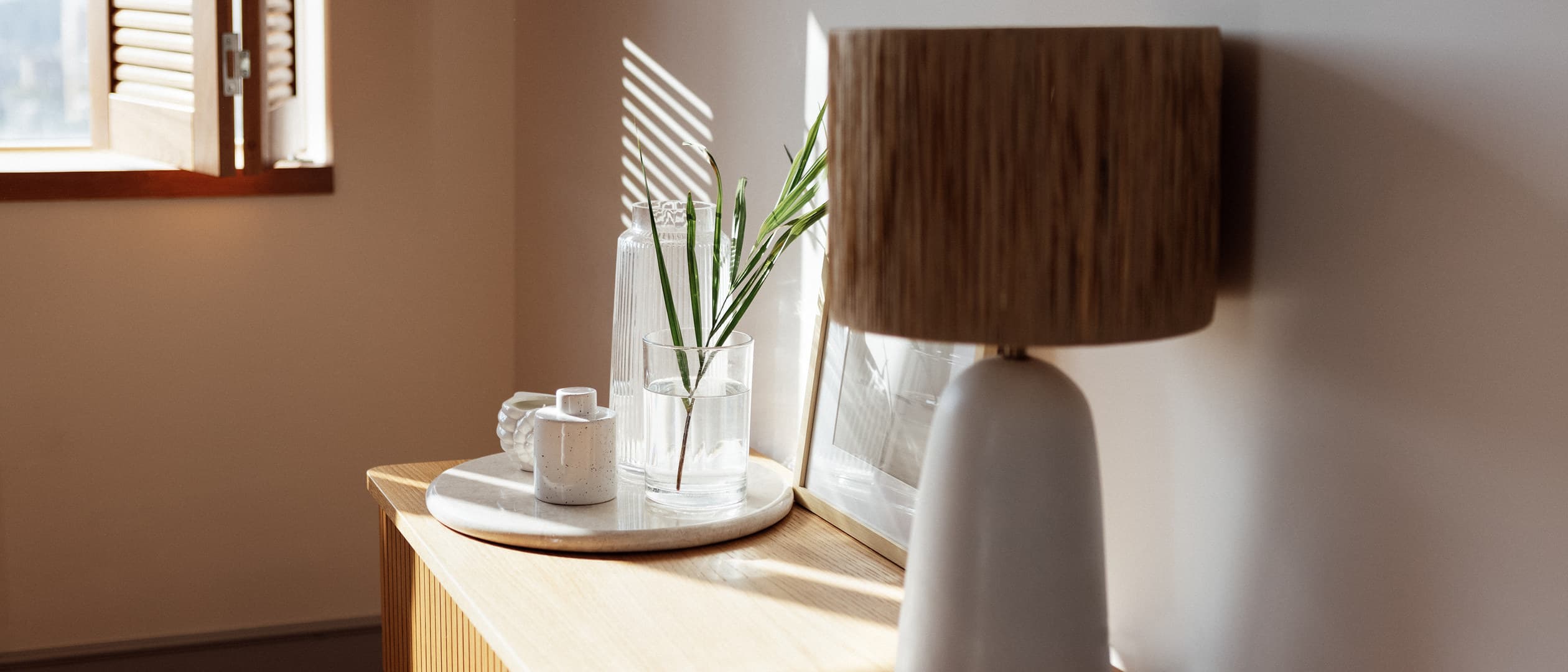 Wood shade table lamp on an oak chest in sunlight