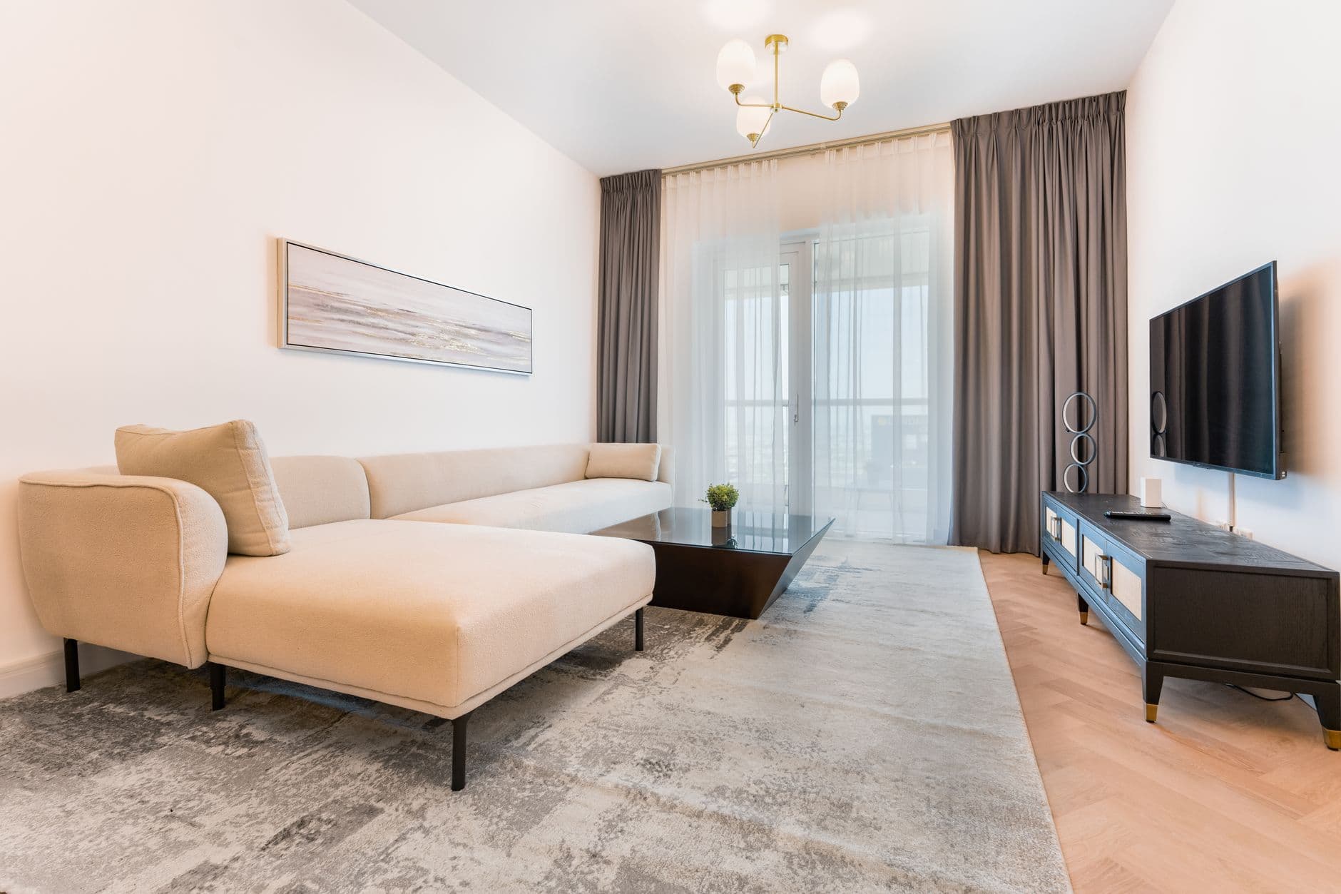 Compact living room with a beige sofa, low coffee table and rug defining the seating area