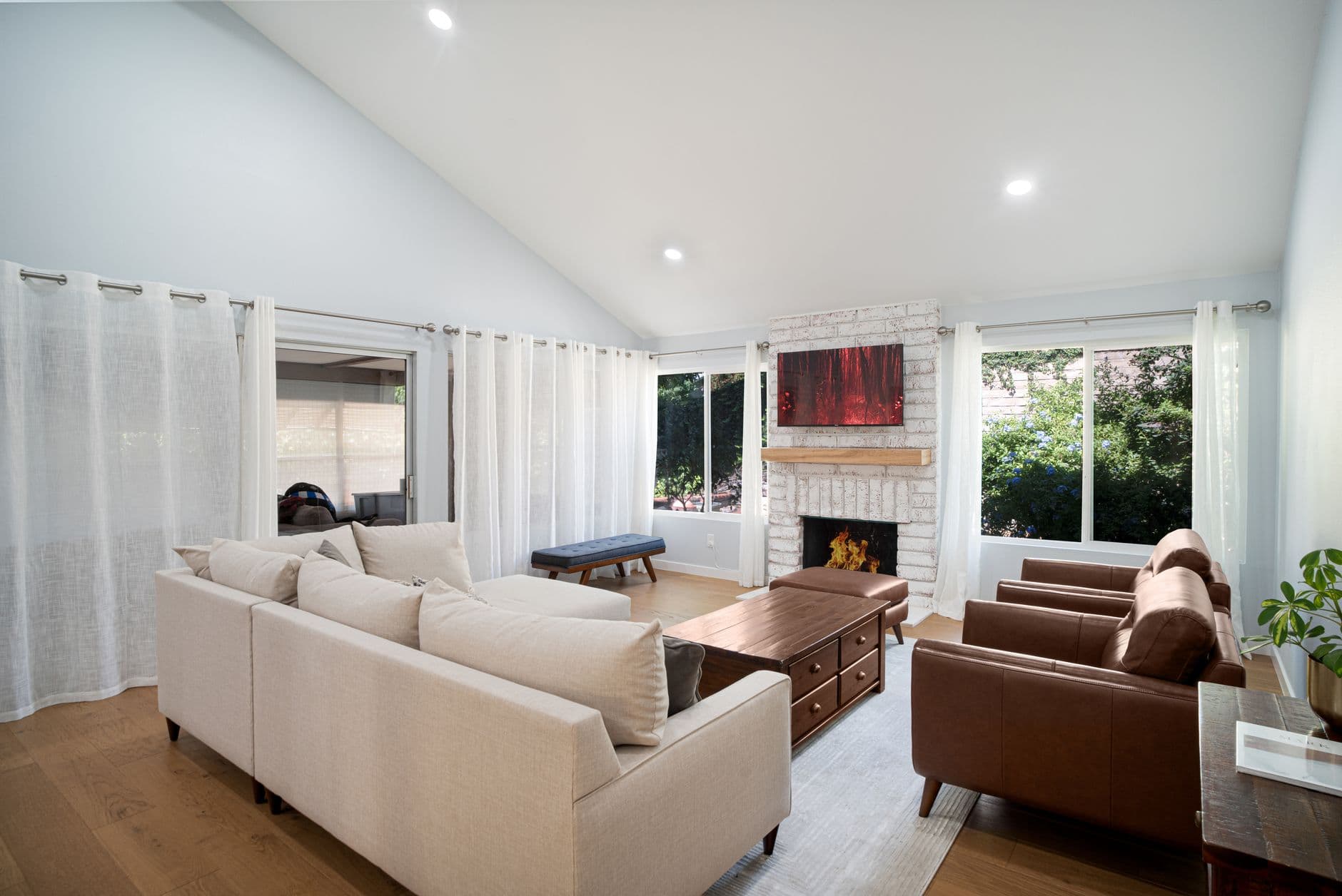 Spacious living room featuring a cozy fireplace, beige sofa, and sleek modern design.