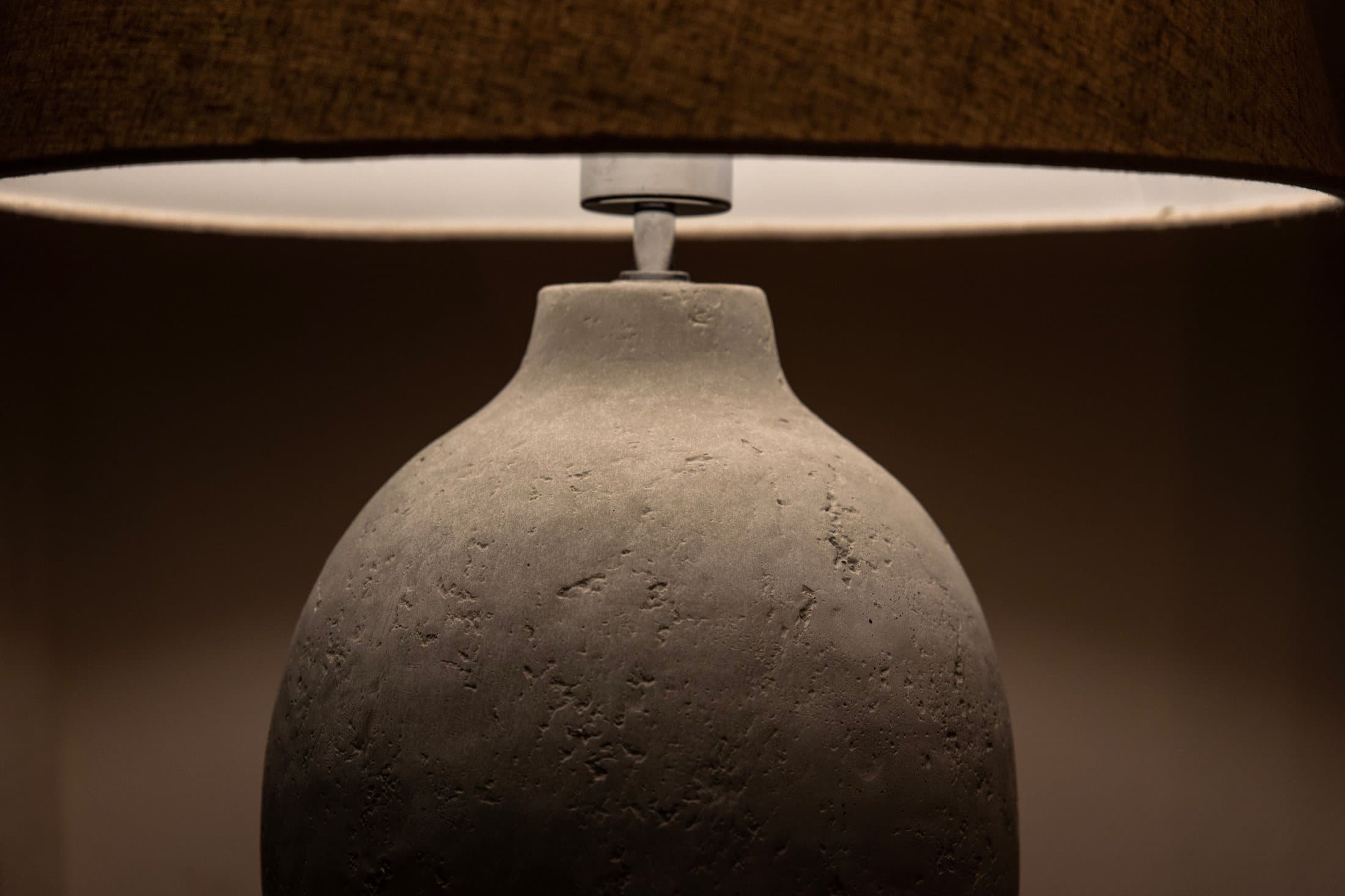 Close view of a stone table lamp with a warm fabric shade