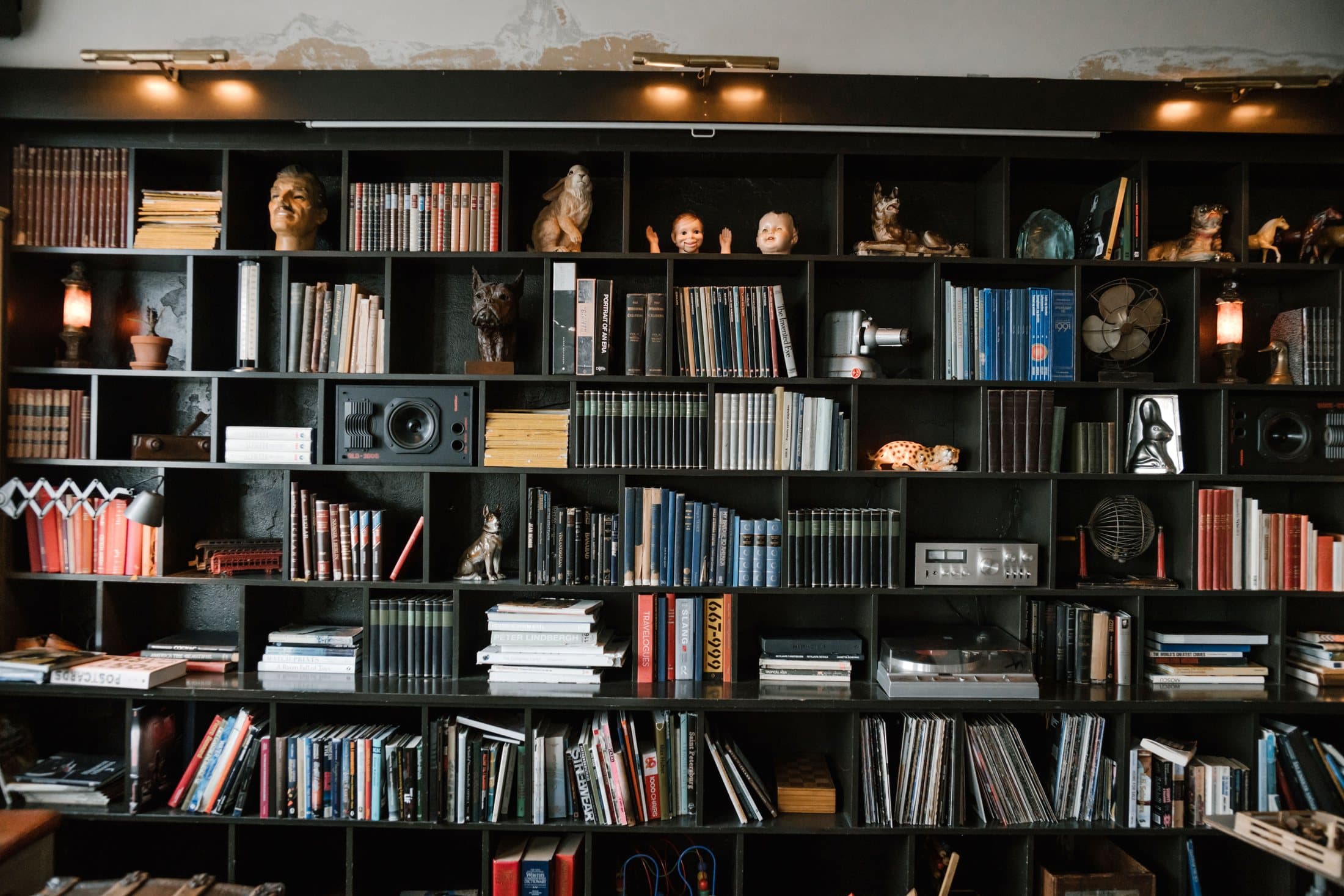 Large bookcase filled with books, art and collected objects